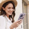 Na zdjęciu widoczne jest etui na telefon z kwiatowym wzorem w odcieniach różu i fioletu, przeznaczone dla modelu Apple iPhone 14 Pro. Etui posiada funkcję MagSafe, co sugeruje obecność okrągłego wzoru na jego powierzchni.