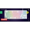 Biała klawiatura z podświetleniem RGB, z widocznymi klawiszami w różnych kolorach, na ciemnym tle. Na klawiaturze znajduje się logo "Gaming X Trust", a poniżej napis "THADO ILLUMINATED TKL GAMING KEYBOARD"; po lewej stronie widoczna jest ikona recyklingu 