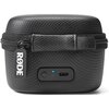 Czarne etui o teksturowanej powierzchni z zamkiem błyskawicznym i uchwytem. Na etui widoczne jest logo "RØDE" oraz panel z przyciskiem, niebieską diodą i portem USB-C.