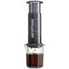 Na zdjęciu widoczny jest zaparzacz do kawy z napisem "AeroPress" na cylindrycznej części urządzenia, z którego do przezroczystego naczynia spływa kawa. Na cylindrze znajdują się oznaczenia poziomów: 8, 6, 4, 2.