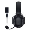 Czarne, nauszne słuchawki z mikrofonem i logo RAZER na pałąku oraz nausznicy, obok znajduje się czarny adapter z napisem "RAZER" i kabel USB. Produkt ma nowoczesny design i jest przeznaczony do bezprzewodowego użytku.