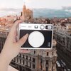 Na zdjęciu widoczny jest aparat fotograficzny trzymany w dłoni na tle miejskiego krajobrazu z budynkami. Na aparacie znajdują się napisy: "FUJIFILM", "INSTAX", "instax mini Evo".