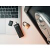 Na zdjęciu znajduje się klawiatura laptopa z podłączonym pendrivem marki Verbatim, obok leży kłódka. Pendrive ma wbudowaną klawiaturę numeryczną i jest widoczny na białym tle.