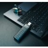 Na zdjęciu znajduje się pendrive z klawiaturą numeryczną podłączony do laptopa, obok którego leżą dwa zamknięte kłódki. Na pendrivie widoczny jest napis "Verbatim".
