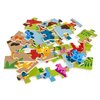 Na zdjęciu widoczne są kolorowe elementy puzzli z motywami dinozaurów i roślinności. Puzzle są rozłożone na białym tle.