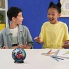 Na zdjęciu znajduje się stół, na którym leży kula z puzzli 3D z motywem Spider-Mana oraz przybory do rysowania i zeszyty. W tle widoczna jest niebieska ściana oraz fragment rośliny i ramki z napisem "Enjoy the little things".
