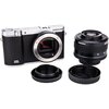 Aparat fotograficzny Samsung NX3000 z widocznym bagnetem, obok obiektyw z napisem "Samsung" oraz dwa czarne dekielki. Na korpusie aparatu widoczny jest napis "NX 3000".