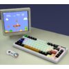 Na zdjęciu znajduje się kolorowa klawiatura mechaniczna z różnobarwnymi klawiszami oraz stary monitor CRT wyświetlający grę w stylu retro z postacią skaczącą po platformach. Obok klawiatury leży kontroler do gier z czterema kolorowymi przyciskami.