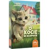 Na okładce gry planszowej "O kocie w kłopocie" widoczny jest rysunek kota z dużymi oczami, stojącego na trawie, z zabawkową myszką obok. W tle znajduje się dom z czerwonym dachem, a w prawym dolnym rogu widnieje logo "muduko".