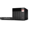 Na zdjęciu widoczny jest czarny serwer plików z czterema zatokami na dyski oraz przełącznik sieciowy z pięcioma portami Ethernet. Na serwerze znajduje się logo "QNAP" oraz etykieta z napisem "TS-x73A Ryzen".