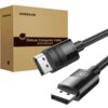 Na zdjęciu widoczny jest czarny kabel DisplayPort z metalowymi końcówkami, na których znajduje się napis "UGREEN" oraz oznaczenie "8K". W tle znajduje się pudełko z napisem "UGREEN Deluxe Computer Cable" oraz chińskimi znakami.
