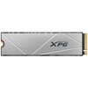 Na zdjęciu widoczny jest dysk SSD z szarym, metalicznym wykończeniem i geometrycznymi liniami, na którym znajduje się logo "XPG". Po prawej stronie widoczne są złote złącza.