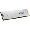 Na zdjęciu widoczny jest srebrny dysk SSD z logo "XPG" na powierzchni, z charakterystycznym wzorem w postaci linii. Dysk posiada złote złącze na jednym z końców.