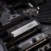 Na zdjęciu widoczny jest dysk SSD z napisem "XPG" zamontowany na płycie głównej komputera. Płyta główna ma ciemne elementy i widoczne są różne złącza oraz komponenty elektroniczne.