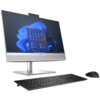 Komputer stacjonarny typu all-in-one z ekranem wyświetlającym interfejs systemu Windows 11, z klawiaturą i myszką na pierwszym planie. Na obudowie widoczne jest logo producenta.