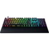 Na zdjęciu znajduje się klawiatura mechaniczna z podświetleniem RGB, z widocznym logo producenta na podkładce pod nadgarstki. Klawisze są podświetlone w różnych kolorach, tworząc efekt tęczy.