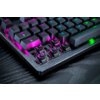Na zdjęciu widoczna jest klawiatura mechaniczna z podświetleniem RGB, z kilkoma zdjętymi klawiszami, ukazującymi przełączniki. Klawisze mają różnokolorowe podświetlenie, a powierzchnia klawiatury jest metaliczna.