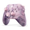 Bezprzewodowy kontroler do konsoli Xbox w wersji specjalnej Dream Vapor, z różowo-fioletowym, marmurkowym wzorem na obudowie. Na kontrolerze widoczne są przyciski z literami Y, X, B, A oraz logo Xbox.
