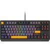 Klawiatura mechaniczna z podświetleniem RGB, posiadająca klawisze w różnych kolorach, w tym żółte klawisze Escape, Spacja i Enter. Na dolnej części obudowy widoczne jest logo "GENESIS".