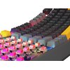 Na zdjęciu widoczna jest klawiatura mechaniczna z podświetleniem RGB, z klawiszami w ciemnym kolorze oraz jednym żółtym klawiszem. Klawisze są uniesione, ukazując czerwone przełączniki mechaniczne, a na niektórych klawiszach widoczne są symbole i litery.