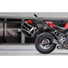Na zdjęciu widoczny jest motocykl z zamontowanym uchwytem na kamerę, który jest pokazany w zbliżeniu na okrągłym powiększeniu. Uchwyt jest przymocowany do tylnej części motocykla, a w tle widać rozmyty budynek.