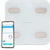Biała waga łazienkowa Götze & Jensen z czterema metalowymi sensorami i wyświetlaczem pokazującym "0.00" kg, obok której znajduje się smartfon z aplikacją wyświetlającą raport pomiaru. Na wadze widoczne jest logo "Götze & Jensen".