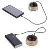 Na zdjęciu widoczna jest lampa kempingowa NILS CAMP NC0005 w kolorze beżowym, podłączona do dwóch różnych urządzeń za pomocą kabli USB. Na lampie znajduje się logo "NILS", a obok niej leżą dwa urządzenia elektroniczne, jedno z wyświetlaczem, a drugie z di