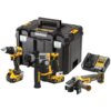 Na zdjęciu znajduje się zestaw elektronarzędzi marki DEWALT, w skład którego wchodzą wiertarko-wkrętarka, młotowiertarka, szlifierka kątowa, ładowarka oraz akumulator, a wszystko to umieszczone obok czarnej skrzynki z logo DEWALT. Na akumulatorach widoczn