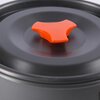 Zdjęcie przedstawia pokrywkę garnka z zestawu turystycznego, wykonaną z ciemnego materiału z pomarańczowym uchwytem w kształcie trójramiennej gwiazdy. Powierzchnia pokrywki jest gładka i matowa, a uchwyt jest wyraźnie zaznaczony na tle reszty.