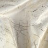 Zdjęcie przedstawia fragment kremowej zasłony z kolekcji EUROFIRANY Malia o wymiarach 140 x 250 cm, z delikatnym, nieregularnym wzorem w odcieniach złota i beżu. Materiał ma lekko połyskującą powierzchnię, co nadaje mu elegancki wygląd.