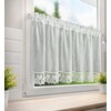 Kremowa firana o wymiarach 150 x 60 cm wisi na oknie, przepuszczając światło. Na dole firany znajduje się ozdobna koronka z motywem roślinnym.