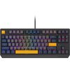 Na zdjęciu znajduje się klawiatura mechaniczna z podświetleniem RGB, z klawiszami w różnych kolorach, w tym żółtym klawiszem "Esc" i spacją. Na obudowie widoczne jest logo "Genesis".