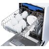 Otwarta zmywarka z widocznym górnym koszem, w którym znajdują się białe filiżanki i talerze. W dolnej części zmywarki widoczny jest pojemnik na detergent.