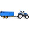 Zabawka przedstawia niebieski traktor z przyczepą do transportu inwentarza, z żółtymi kołami i szarymi elementami. Na przyczepie widoczne są żółte naklejki z czarnymi symbolami ostrzegawczymi.