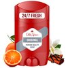 Czerwony dezodorant w sztyfcie z napisem "24/7 FRESH" na górze oraz "Old Spice Original" i "PERFUME QUALITY SCENT" na etykiecie. Obok produktu znajdują się połówka pomarańczy, laska cynamonu, wanilia i kwiat.