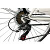 Zbliżenie na mechanizm tylnej przerzutki roweru z widocznym napisem "Shimano Tourney TZ" na czarnej obudowie. W tle widać zębatki oraz fragmenty białej ramy roweru.
