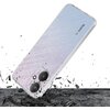 Przezroczyste etui na telefon z widocznym napisem "Redmi" i "5G" jest przedstawione w dynamicznej scenie, gdzie wokół niego unoszą się fragmenty rozbitego materiału. Tło jest białe, a powierzchnia, na której leży etui, wygląda na popękaną.