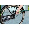 Na zdjęciu widoczna jest ręka trzymająca szczotkę do felg, która jest używana do czyszczenia koła roweru, z wodą tryskającą z końcówki szczotki. Produkt ma napis "DUNLOP" na obudowie.