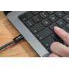 Na zdjęciu widać klawiaturę laptopa z podłączonym kablem USB-C, na którym widnieje napis "XLINE". Obok klawiatury znajduje się dłoń naciskająca klawisz.
