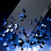 Czarne etui z teksturą przypominającą szczotkowany metal jest przedstawione w dynamicznej kompozycji z niebieskimi, rozpraszającymi się fragmentami. Na zdjęciu widoczny jest detal przeszycia oraz zarys przycisku na krawędzi etui.