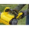 Żółta dmuchawa do liści z widocznym logo "STANLEY FATMAX" oraz akumulatorem oznaczonym jako "V20 LITHIUM ION 4.0Ah". Produkt trzymany jest w rękach w rękawicach ochronnych na tle trawnika.