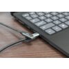 Na zdjęciu widać czarny laptop z klawiaturą, do którego podłączony jest pleciony kabel USB-C. Na wtyczce kabla widoczny jest symbol USB.
