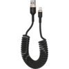 Czarny, spiralny kabel USB-A do Lightning z metalicznymi akcentami na końcówkach, na których widoczne jest logo w kształcie litery "M". Kabel ma długość 1,5 metra.