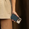 Osoba trzyma w dłoni czarny powerbank oraz smartfon. Na powerbanku widoczny jest napis "NATIVE UNION".