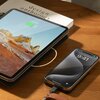 Na zdjęciu znajduje się tablet z wyświetlonym krajobrazem górskim i wskaźnikiem naładowania baterii na poziomie 67%, leżący na książce z widocznym tytułem "design anthology". Obok znajduje się smartfon z wyświetlaczem pokazującym godzinę 9:41 i datę "Tues