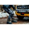 Na zdjęciu widać osobę w śniegowcach roboczych STALCO S-48013 (rozmiar 40), która stoi na zaśnieżonej drodze obok żółtego pojazdu z widoczną tablicą rejestracyjną "DW 1TF25". Na pojeździe znajduje się logo "Ford", a w tle widać zaśnieżony las.