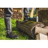 Na zdjęciu widać osobę w półbutach roboczych STALCO Tomas OB S-51480, stojącą na pniu drzewa z siekierą wbitym w drewno. W tle znajduje się stos drewna opałowego.