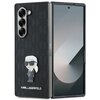 Czarne etui na telefon z wytłoczonym wzorem i przypinką przedstawiającą postać w okularach przeciwsłonecznych. Na etui widnieje napis "KARL LAGERFELD", a na krawędzi telefonu napis "SAMSUNG".