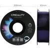 Na zdjęciu widoczna jest szpula filamentu do drukarki 3D z napisem "CREALITY 3D PRINTER FILAMENT" oraz kolorowym wzorem przypominającym mgławicę. Na etykiecie znajdują się informacje: "CR-PETG, Diameter: 1.75MM, Net Weight: 1KG, Extruder Temp: 230°C-250°C