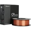Czarna pudełko z napisem "CREALITY CR Series 3D Printing Filaments" oraz "MADE IN CHINA" stoi obok szpuli miedzianego filamentu. Na pudełku widoczne są również kolorowe paski z opisami oraz tekst "SHENZHEN CREALITY 3D TECHNOLOGY CO., LTD" i "3D Printing I